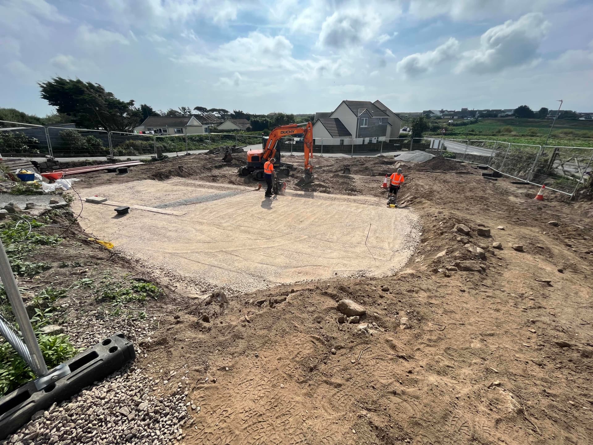Excavator and roller compacting the foundation build up for the passive properties at Sunny Banks, Sennen
