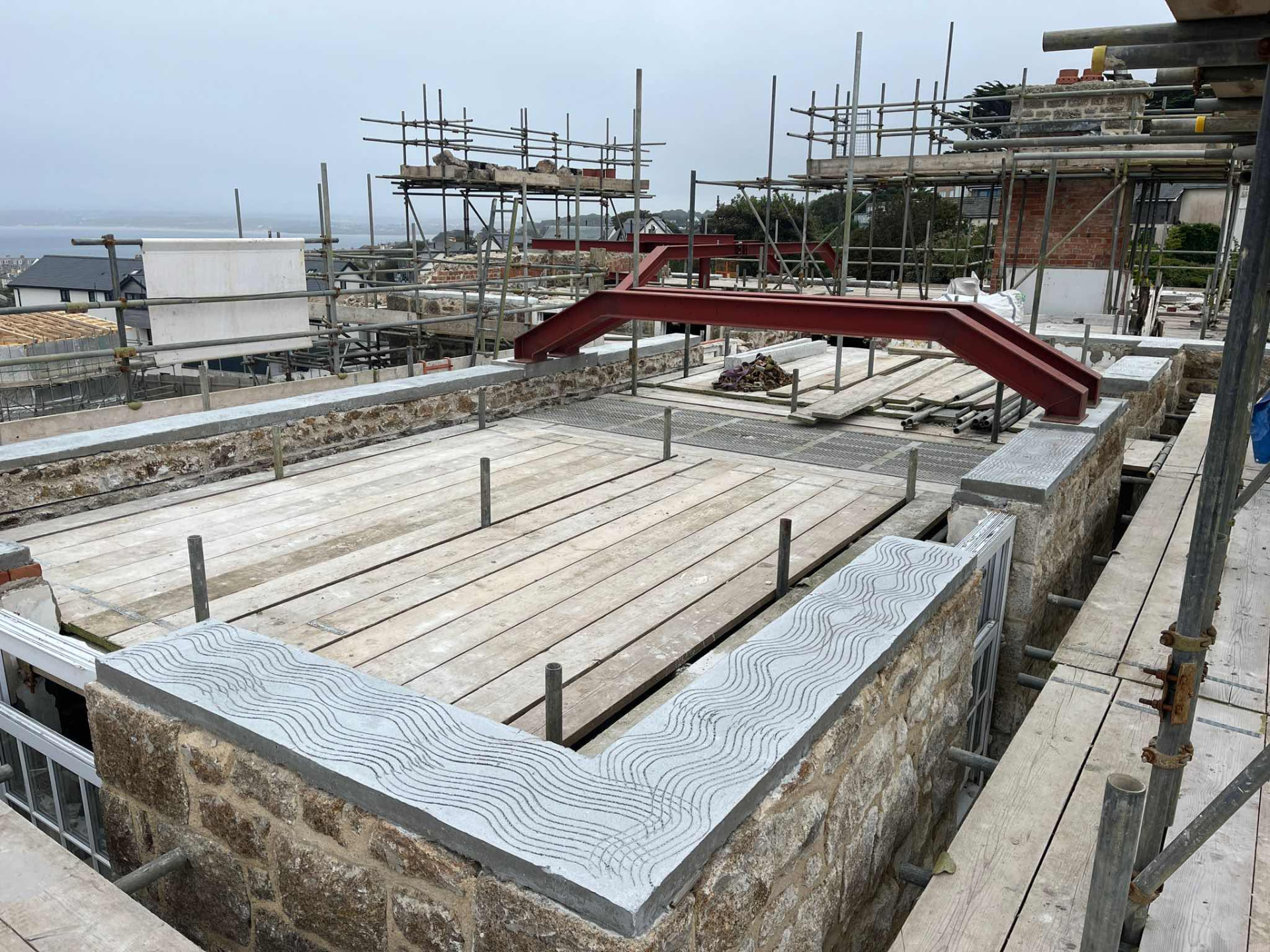 Steel beams and stone walls with a textured concrete coping during works at The Garrack Hotel