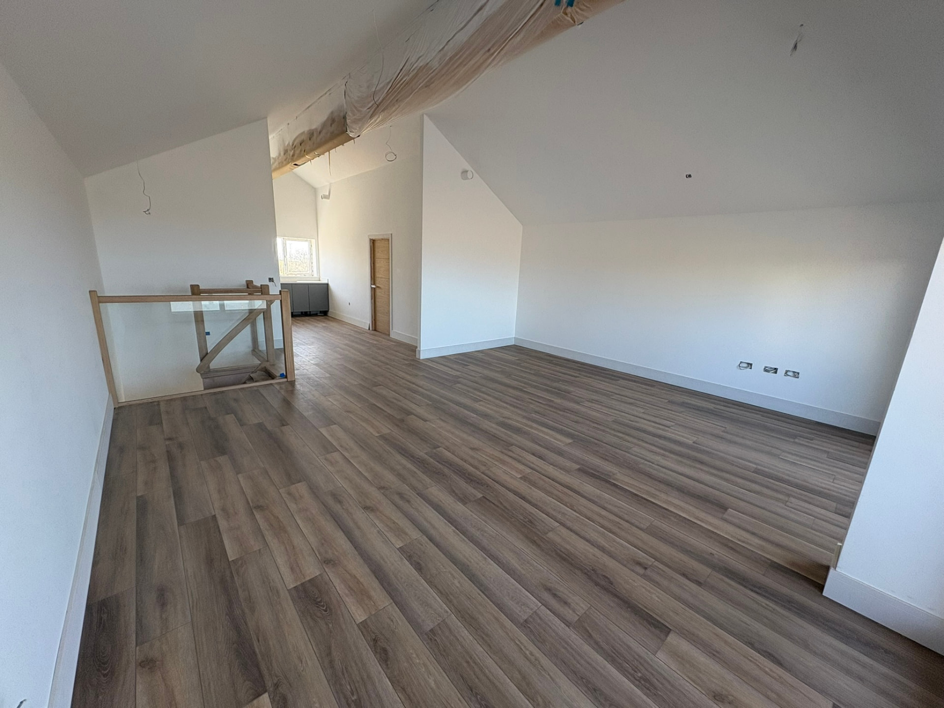 Finished interior with oak and glass staircase inside one of the passive properties at Sunny Banks, Sennen