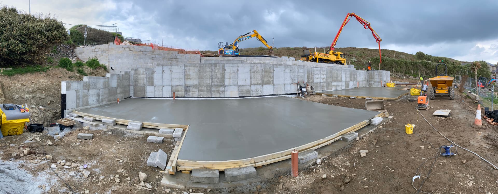 Freshly poured ground-floor slabs in front of reinforced concrete retaining walls at the Porthleven new build site in Cornwall